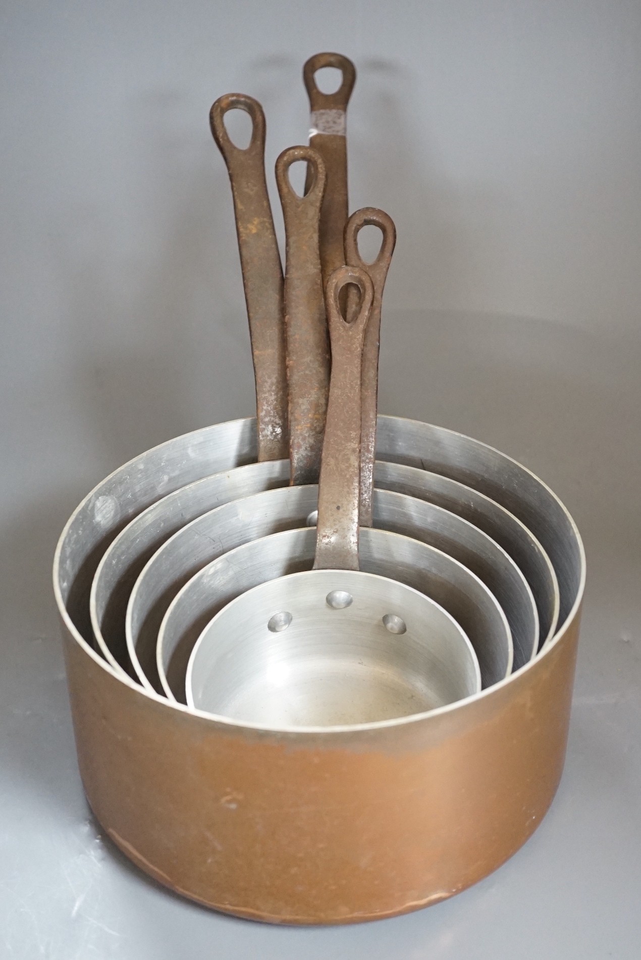 A graduated set of French copper saucepans